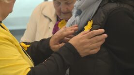 Ľudia v uliciach pomáhajú onkologickým pacientom pripnutím narcisu na znak solidarity 